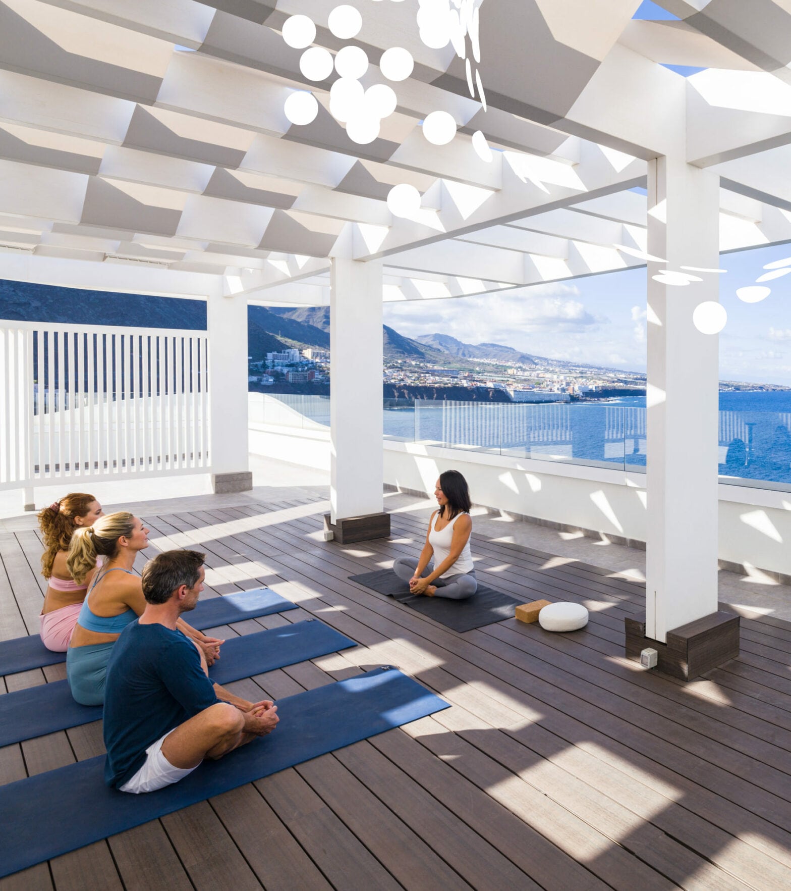 Yogagruppe sitzend Dachterrasse